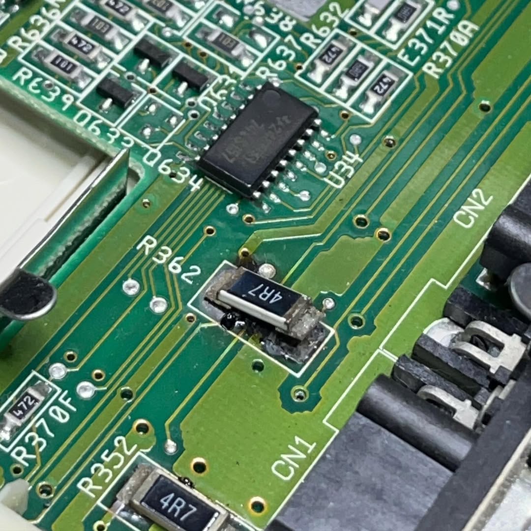 Resistenza R362 gravemente bruciata su Amiga 600, con evidenti segni di annerimento e danneggiamento della PCB